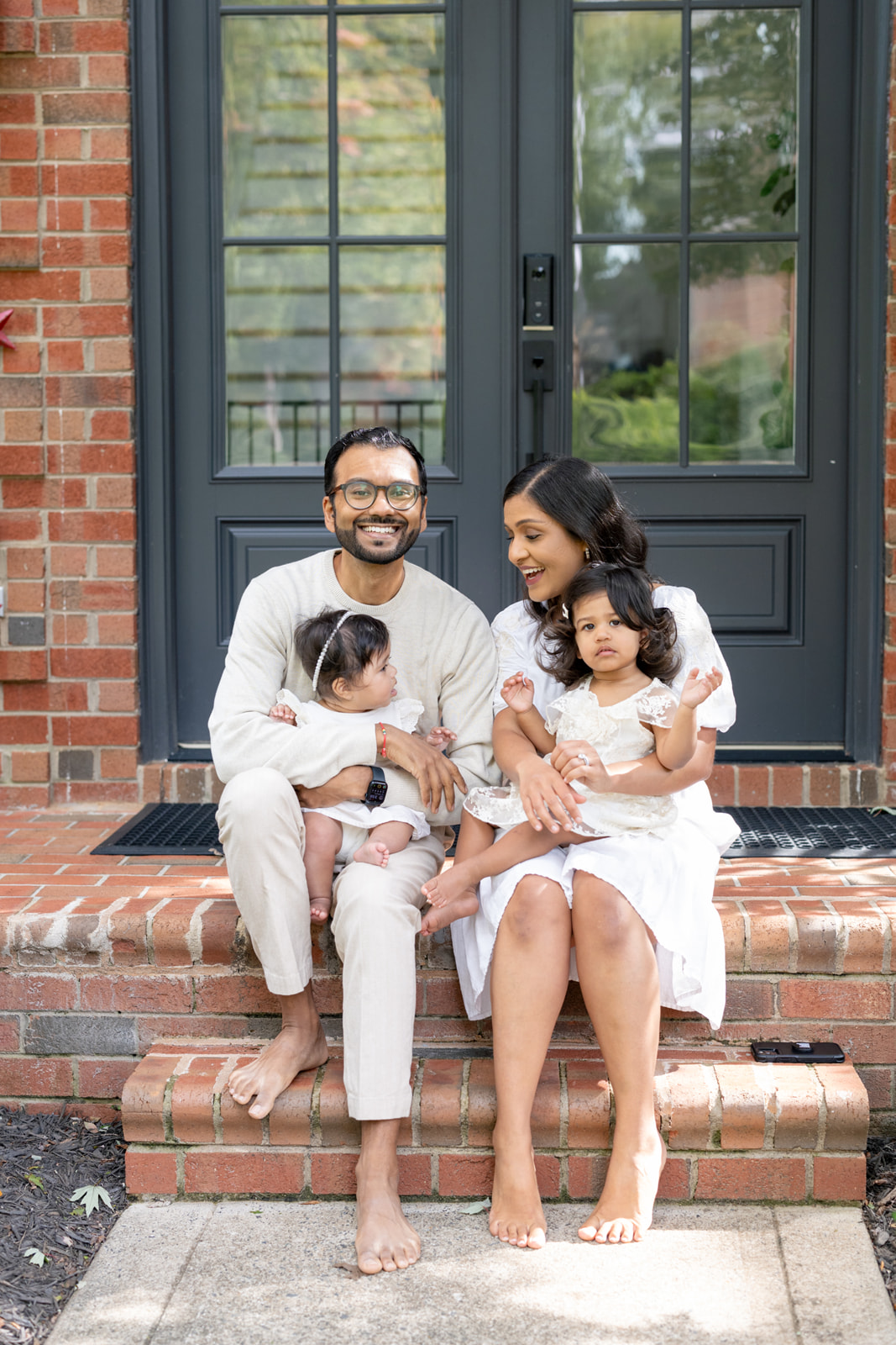 Mom and Dad at their home in Charlotte North Carolina during their family session holding their 2 ldaughters
